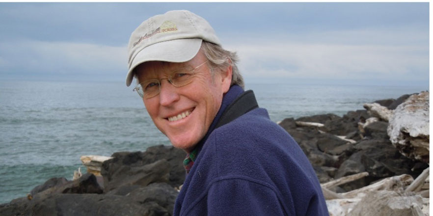 Don Snow smiling outdoors near the ocean