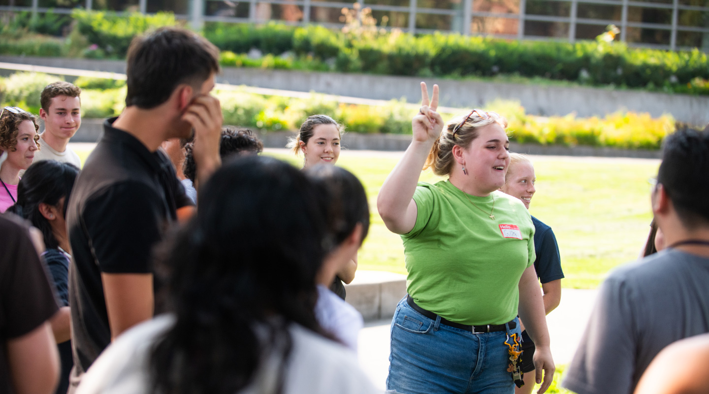 Students outside listening to a guide speak