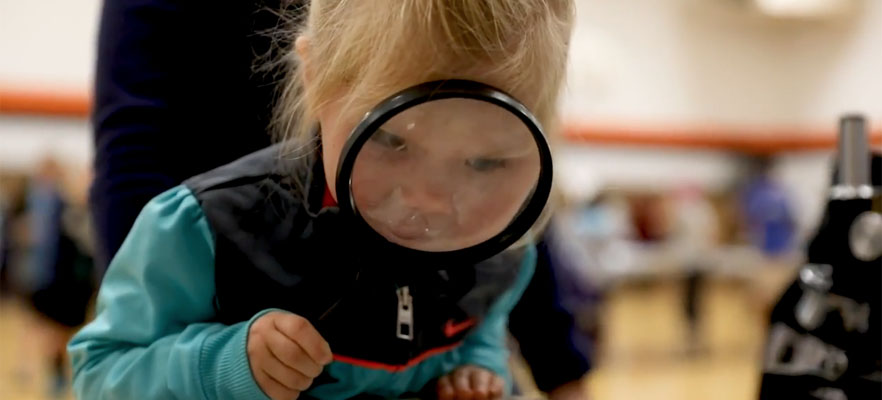 Berney Student looking through magnifying glass