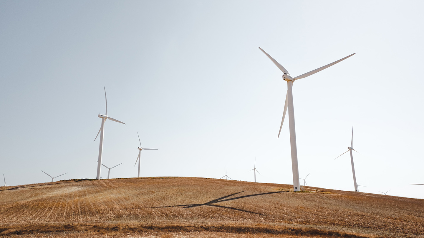 Wind mills in the distance on a farm landscape