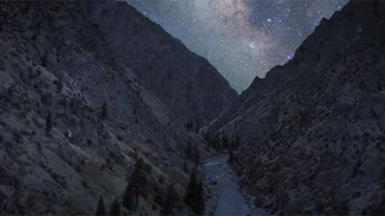 River running through mountains as seen at night.