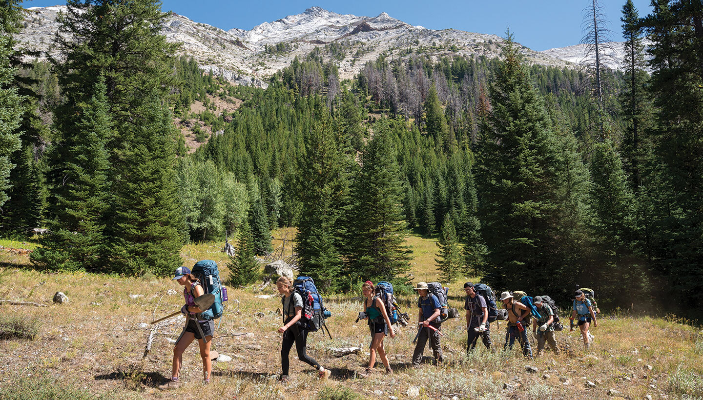 Students backpacking outdoors.
