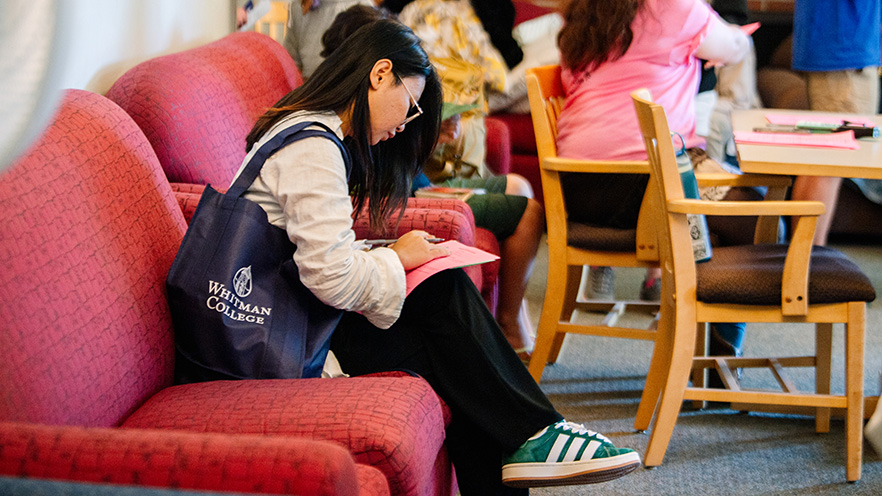 Whitman College student looking over a list on move in day.