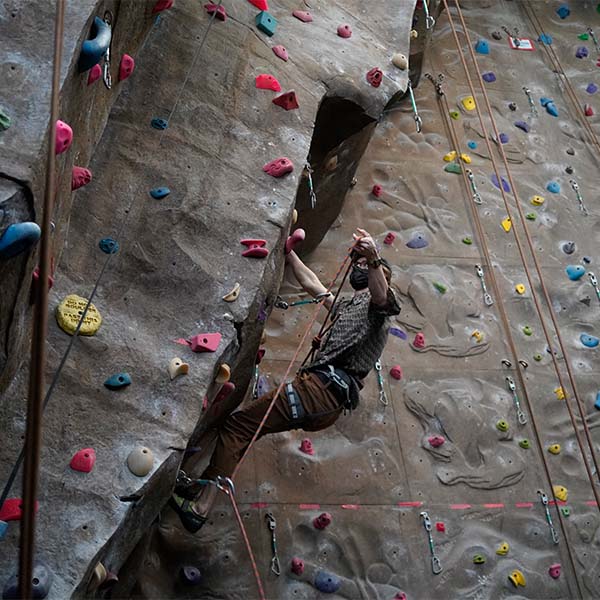 A rock climber on an inddor climbing wall.