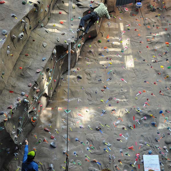 A climber high up on an indoor wall.