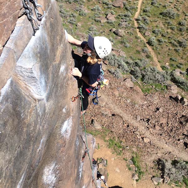 A rock climber high up on a sheer cliff.