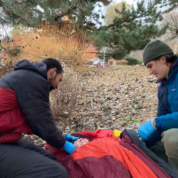 Practicing wilderness first aid in the outdoors.