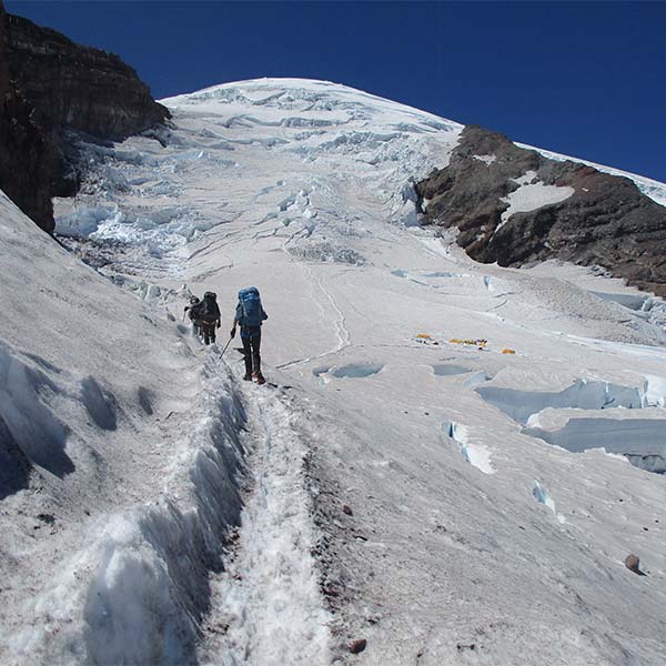 Mountaineers making a path through the snow towards the summit.