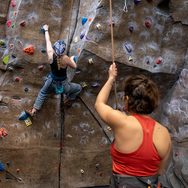 Whitman College students at the college's climbing center rock climbing.