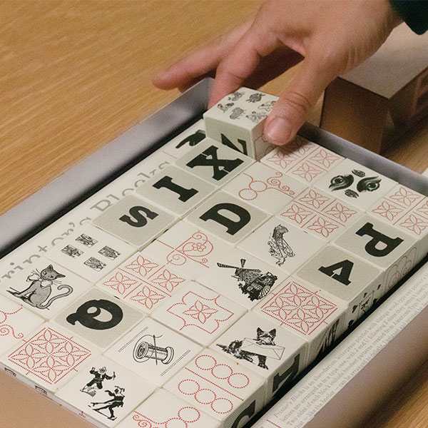 A student manipulates an artists' book made out of blocks.
