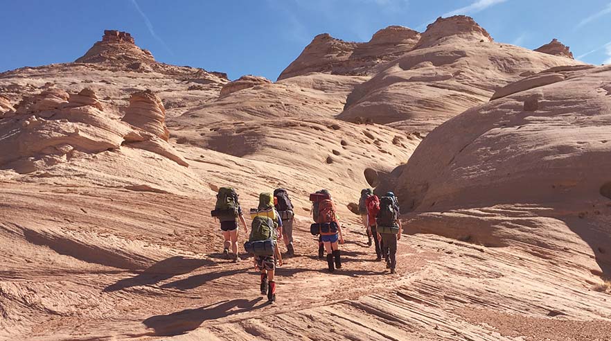 A group of students hiking in the desert.