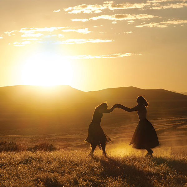 two silhouettes dancing at sunset.