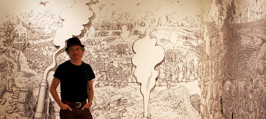 Artist Joe Sacco with an enlarged image from his 2013 graphic novel, "The Great War"