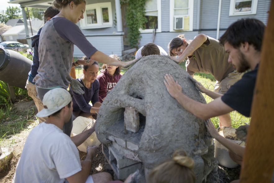 Students working together to build a cob oven