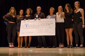 Students present check to Health Center staff.