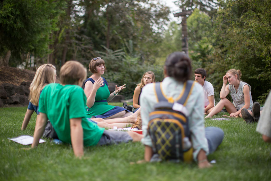 This image needs a real description other than "new classes." The image shows students and a professor having a class outdoors.