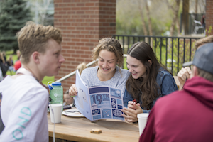 Students pour over the conference program between sessions during the all-campus lunch.