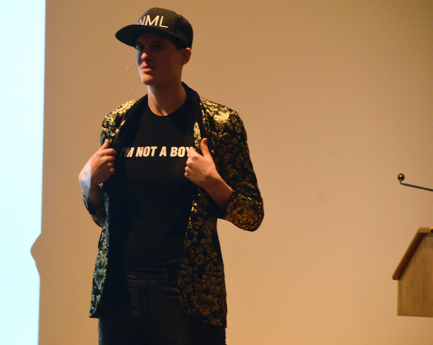 Rain Dove speaking on stage in Maxey Auditorium