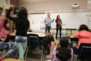 Classroom image from Whitman Teaches the Movement (students raising hands)