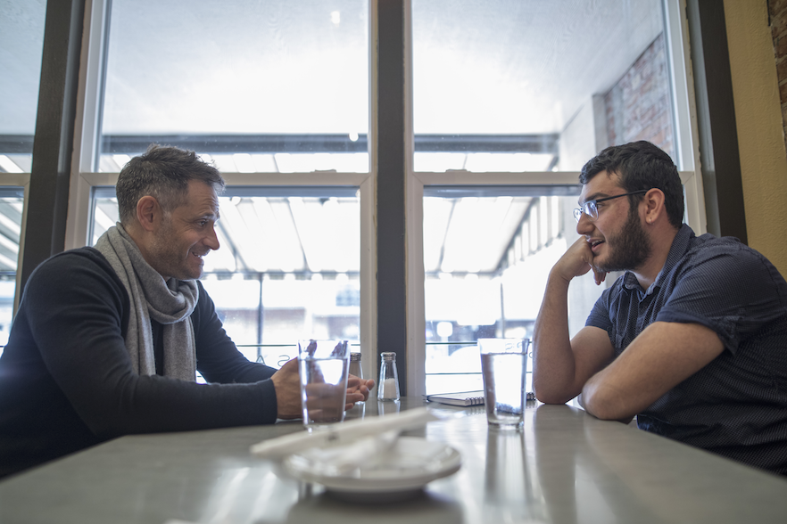 Author Alexander Maksik '95 (left) and Bashar Haidar '20 share a meal at Walla Walla's Olive Market Place & Cafe.