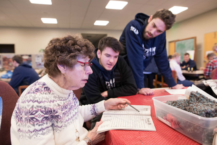 A mutual fan club between Cedric Jacobs-Jones ’19, a wing player, and Cynthia, a resident. A HopeTree staffer, Vera, assists.  