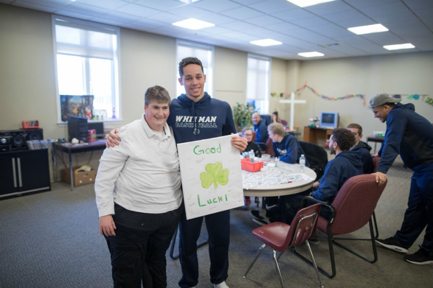 A mutual fan club between Cedric Jacobs-Jones ’19, a wing player, and Cynthia, a resident. A HopeTree staffer, Vera, assists.  