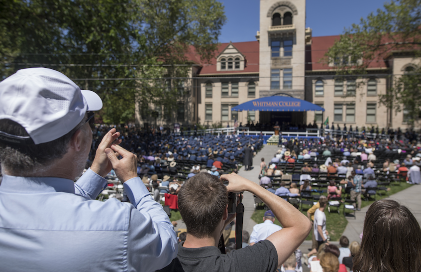 Parents and relatives applaud from the bleachers as seniors receive their diplomas.