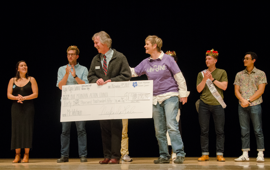 Jeff Mathias, food bank director for Blue Mountain Action Council, accepts a check on behalf of his organization, accompanied by Lincoln High School intervention specialist Brooke Bouchey.