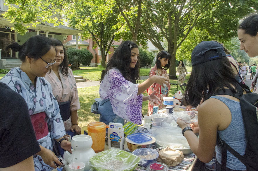 Whitties learn how to make learn how to make onigiri, a type of Japanese rice ball, at the Tekisuijuku (Japanese Studies House) table during the IHC block party.