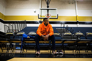 Tim Howell sits on a chair in a gymnasium.