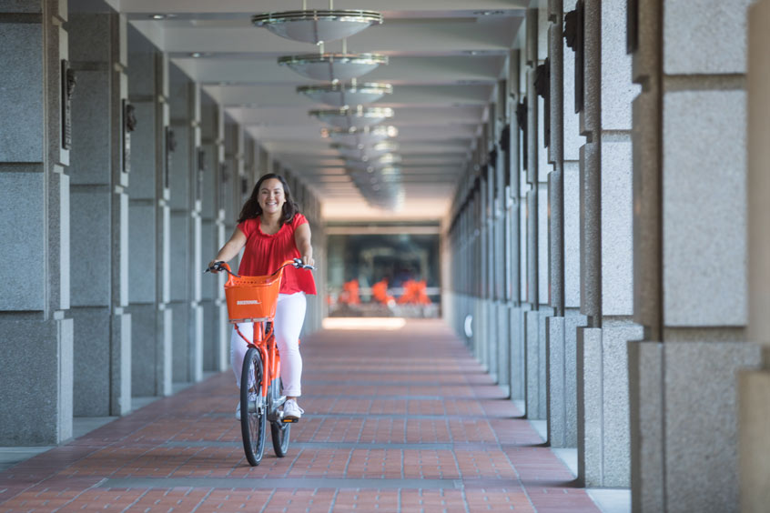 Holloway biking next to John McEnroe building on the Nike campus