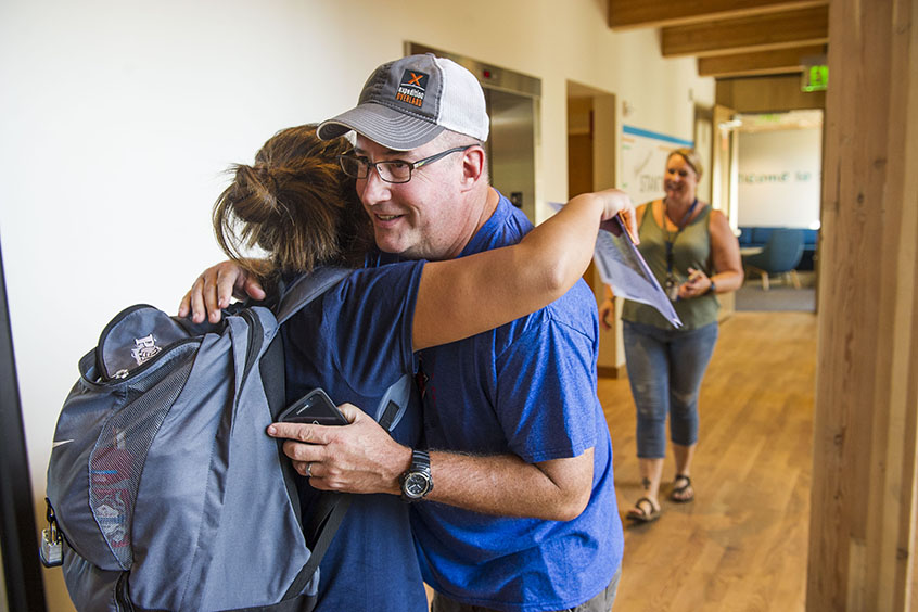 A father hugs his student during move-in.