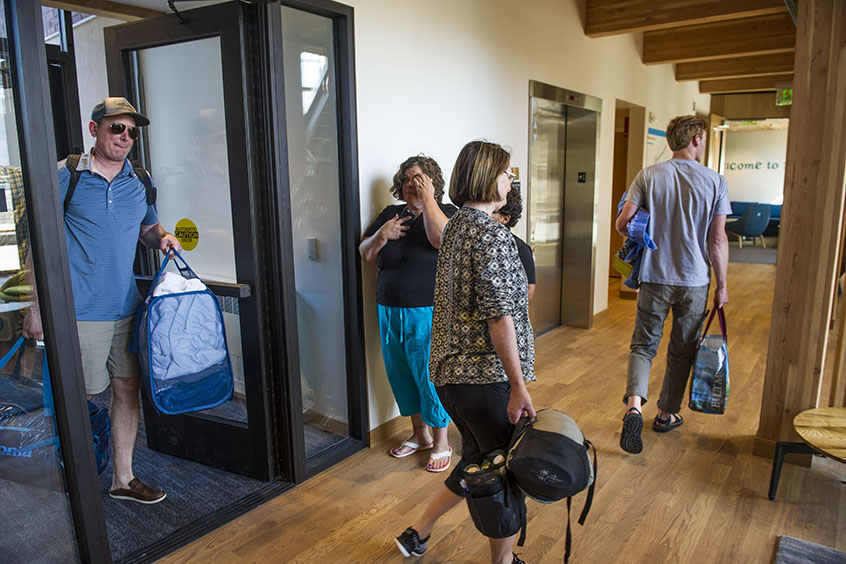 Families walk in to Stanton Hall with luggage.