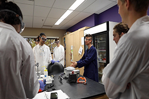 Brit Moss teaches students at a lab table.