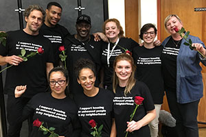 Becky Avila and other advocates hold roses at an event.