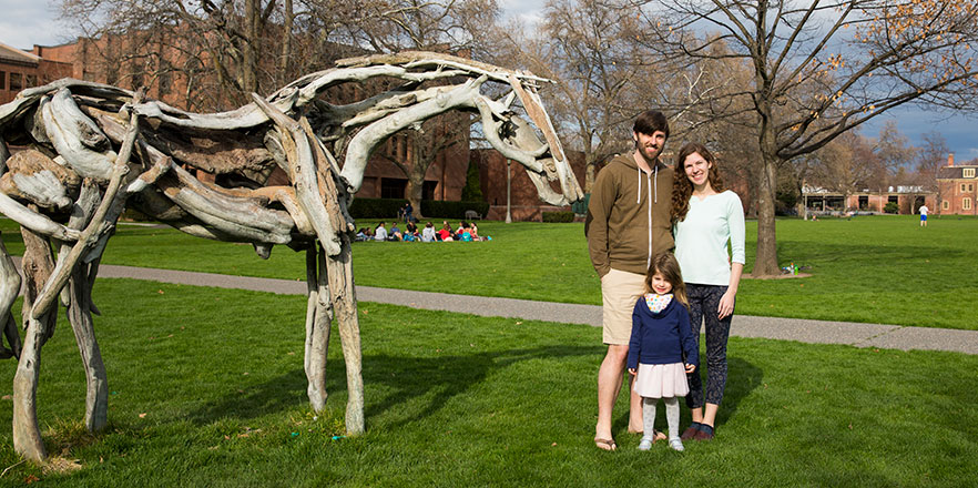 A portrait of Ben, Kate and Brienne VanDonge next to the Styx sculpture on Akeny Field.