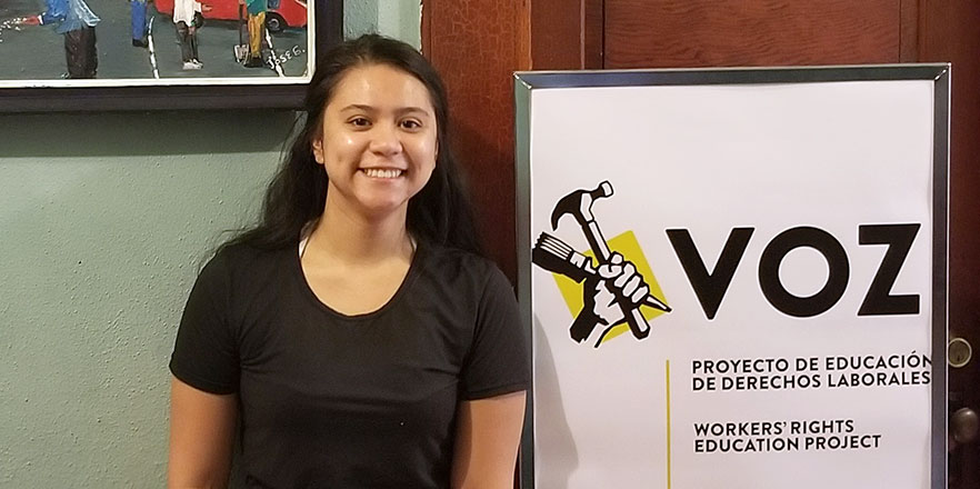 Mayrangela Cervantes stands in front of a Voz sign in Portland.