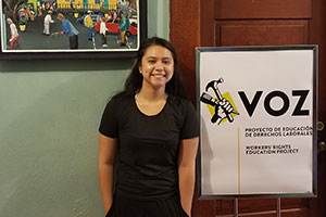 Mayrangela Cervantes stands in front of a Voz sign in Portland.