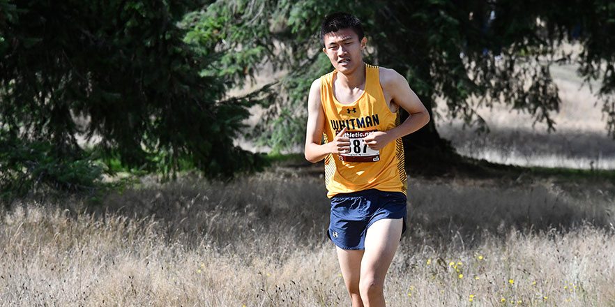 Carl Ye runs through a field.