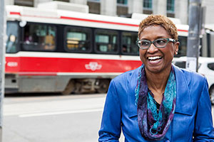Paula Boggs smiles in front of a transit bus.