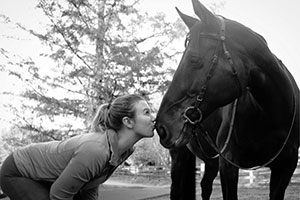 Cello Lockwood kisses a horse on the nose.