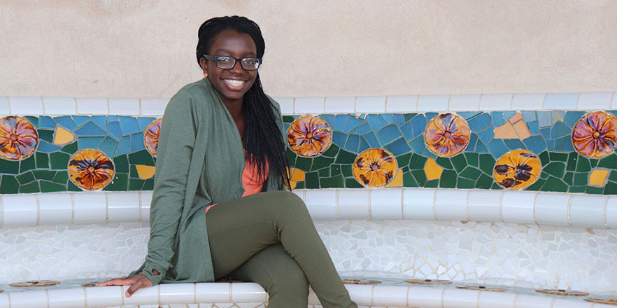 Dorothy Mukasa smiles while sitting on a bench.