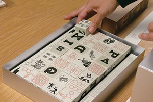 A student manipulates an artists' book made out of blocks.