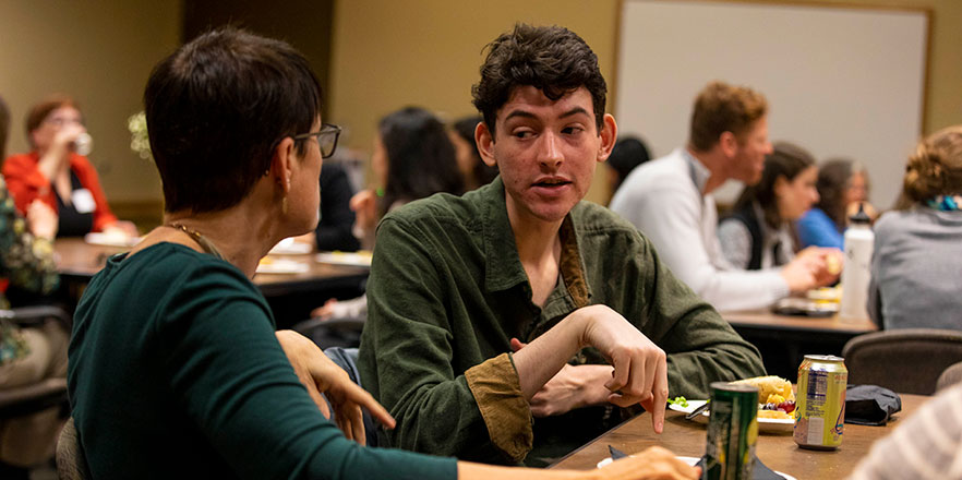 Matt Levy speaks with a community member at a luncheon for the Whitman Consulting Corps