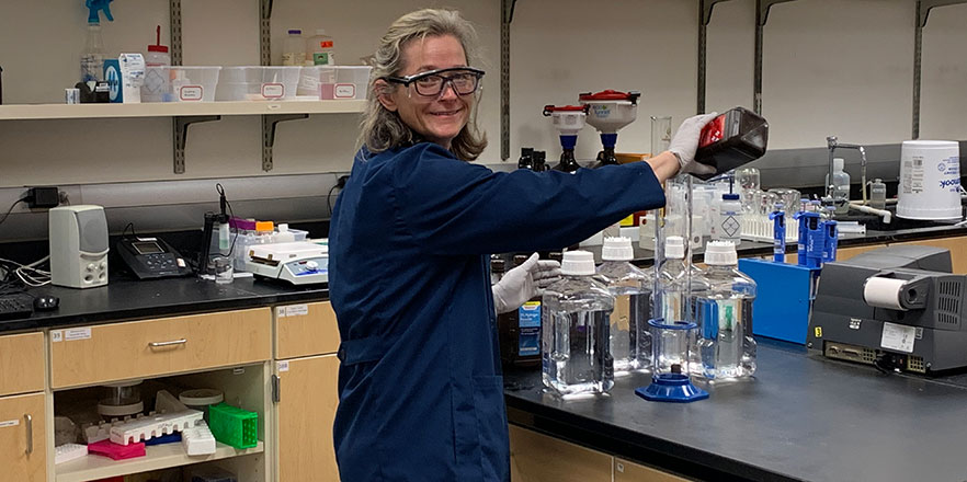 Sarah Kirk '95 works in a lab mixing chemicals for hand sanitizer at Willamette University. 