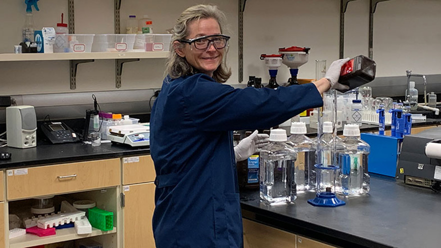 Sarah Kirk '95 works in a lab mixing chemicals for hand sanitizer at Willamette University.