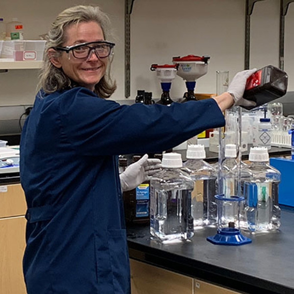 Sarah Kirk '95 works in a lab mixing chemicals for hand sanitizer at Willamette University.
