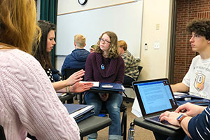 Students sit in chairs and talk to alumni during sophomore summit.