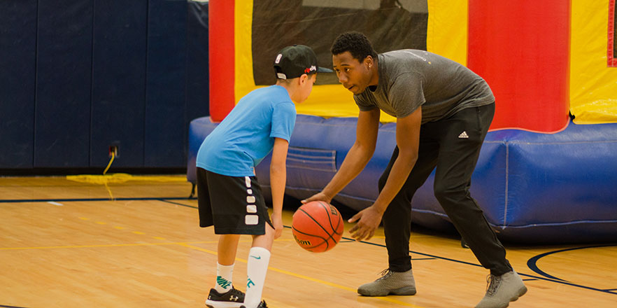 A Whitman student plays basketball with an elementary school student.