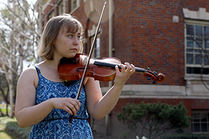Rose Heising plays the violin outside Hunter Conservatory.
